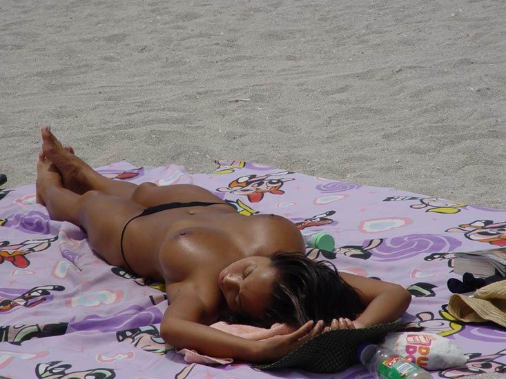 Голая подруга отдыхает на пляже с открытыми титьками